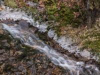 Schmale Kaskade im Steinbach flankiert von Eisschicht